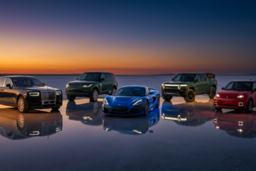 Five luxury cars in a row on glossy wet ground reflect a stunning sunset. The sky is a blend of deep blue and orange, creating an elegant scene.